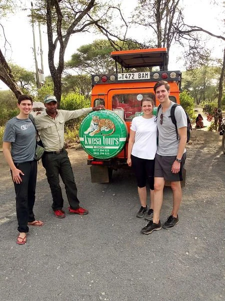 Kwesa team and travellers beside a safari vehicle
